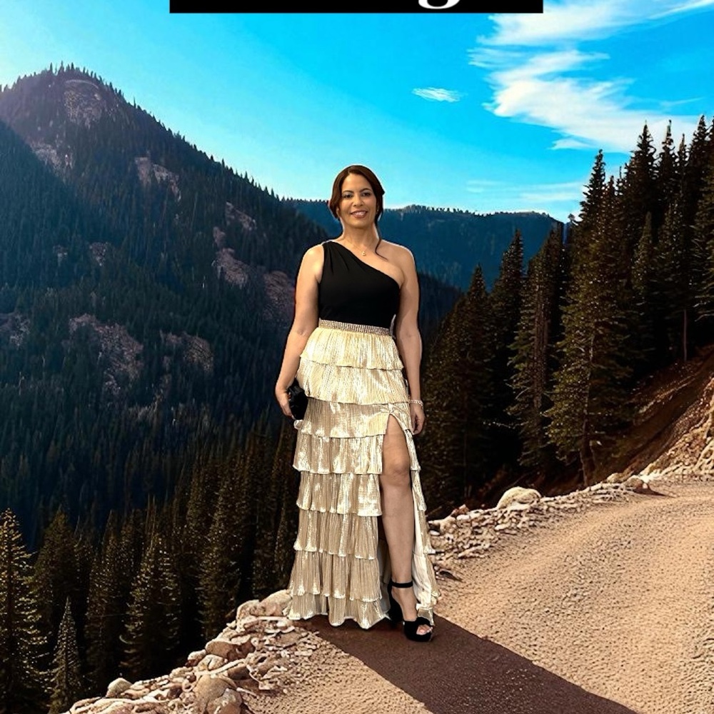 Elegant layered gold skirt gown with a black one-shoulder fitted top.